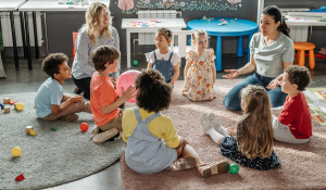childcare center- teacher playing with kids in circle time